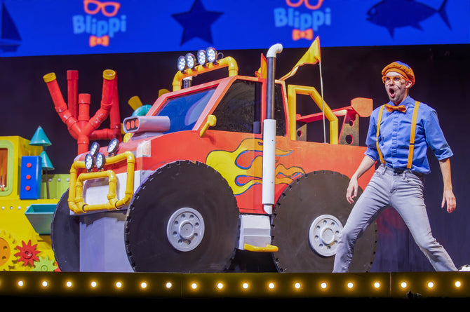 Blippi on stage with a monster truck.